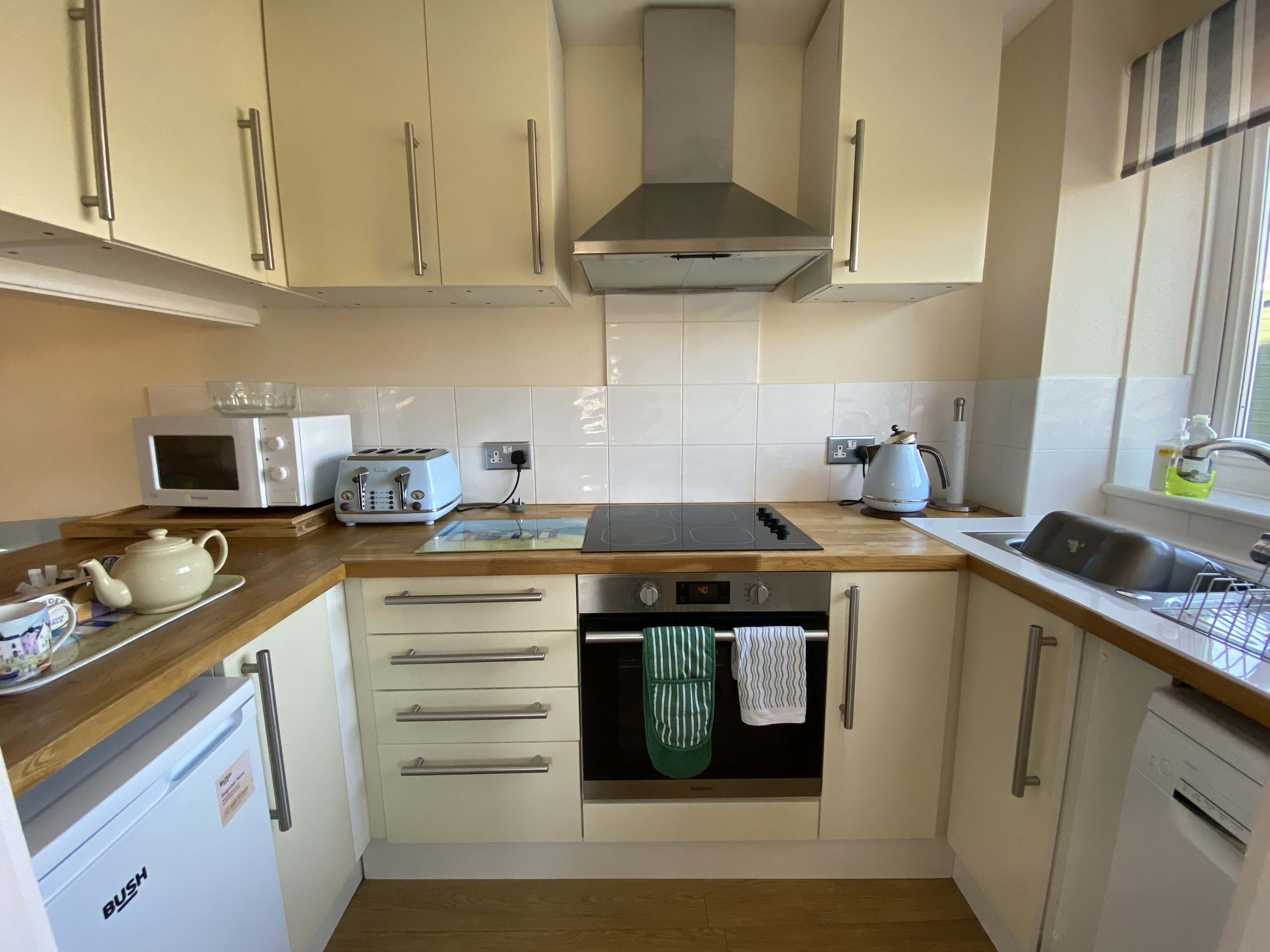 A neat and tidy kitchen with pale blue appliances and matching tea towel hung on oven door handle